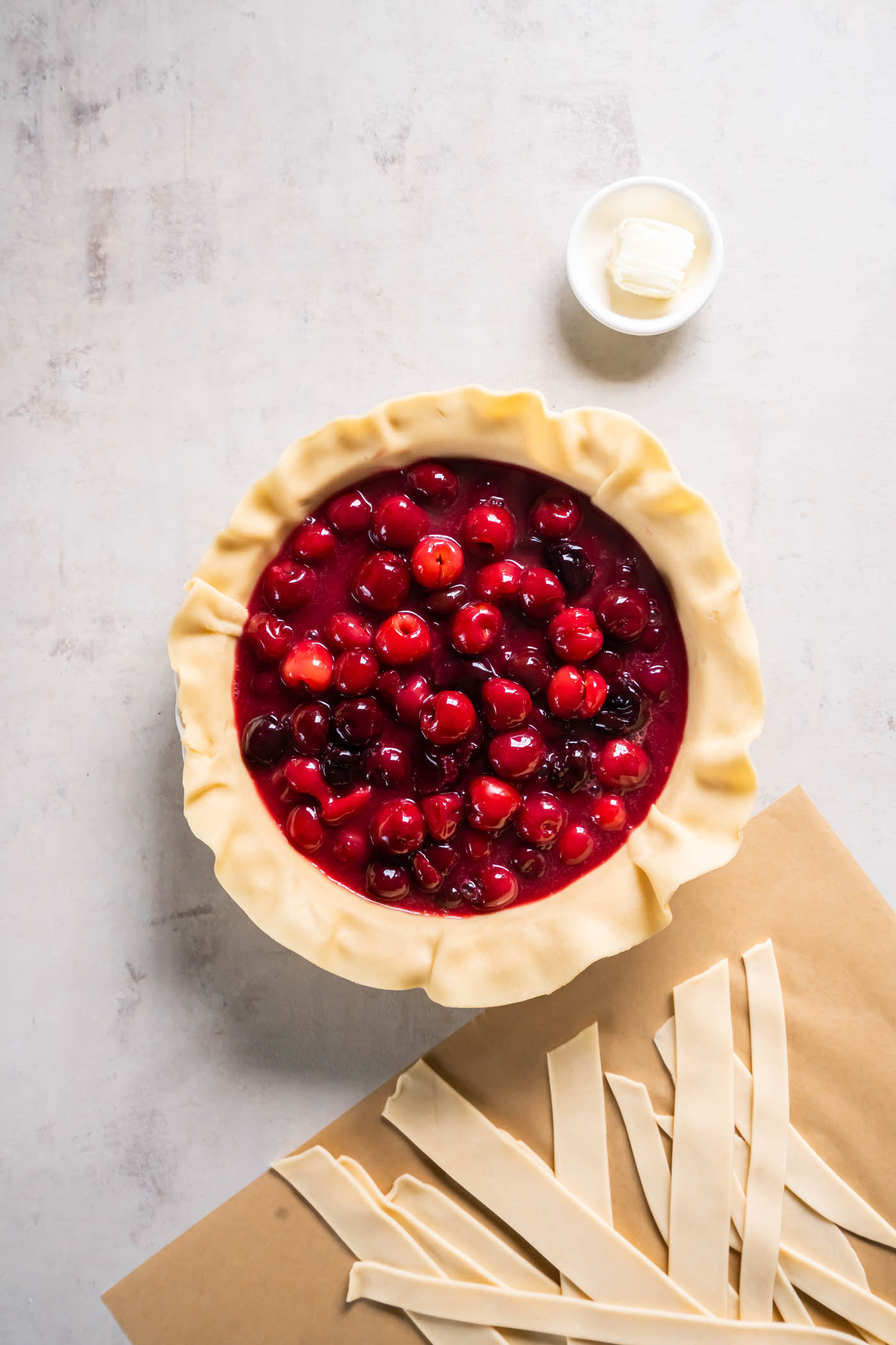 Cherry pie filling in pie crust before baking.